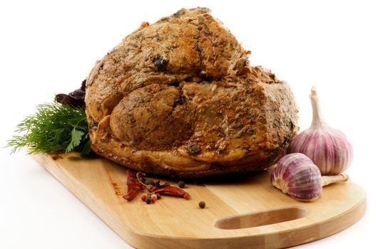 Roasted Pork Tenderloin Full Body on Cutting Board with Greens, Pepper and Garlic isolated on white background