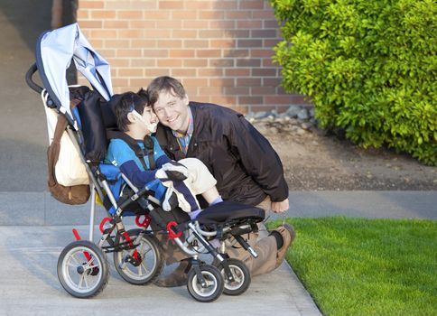 Disabled boy in wheelchair and his father