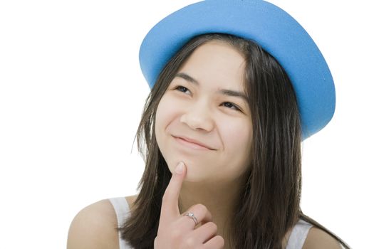 Beautiful young teen girl in blue hat, looking up with thoughtful expression, as if just had an idea.