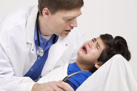 Male doctor in early forties comforting five year old disabled patient during office visit