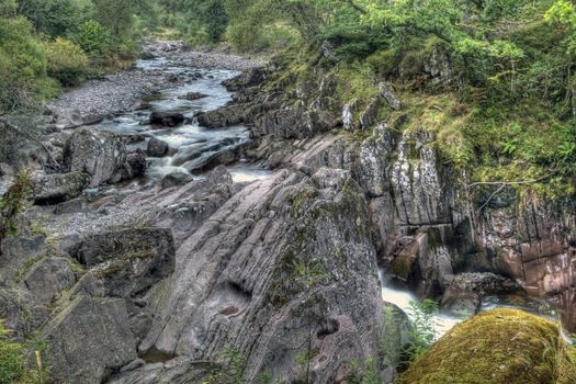 Rocks surround a flowing stream in Scotland