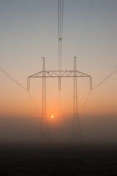 Transmission towers on the hills in the mist