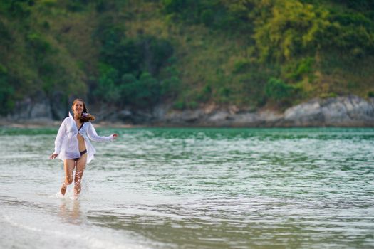 Young woman running along the seacoast