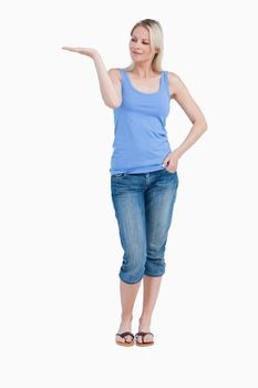 Blonde woman looking at her right hand palm up against a white background