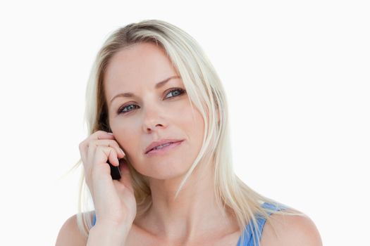 Blonde woman looking to the side while calling against a white background