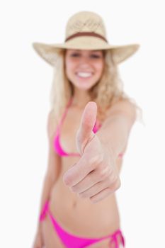Thumbs up showed by an attractive smiling woman against a white background