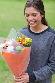 Young smiling girl receiving a beautiful bunch of flowers