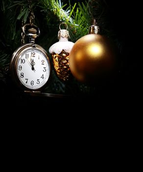 Vintage pocket watch hanging on Christmas tree near decorations