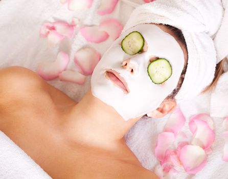 Woman in beauty salon receiving facial mask