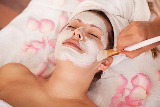 Young women getting facial mask. Spa studio shot