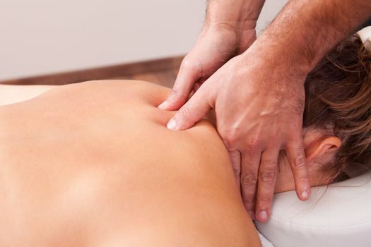 Young beautiful woman getting back massage. Spa studio shot