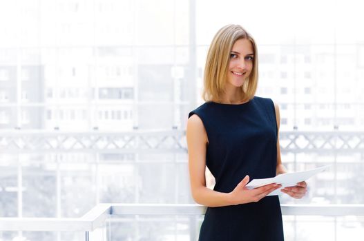 business woman holding reports and looking to the camera, copy space