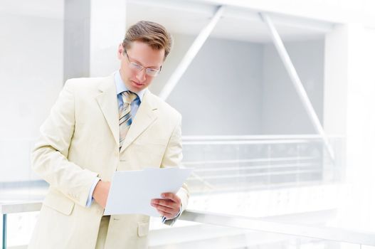 Smiling business man in glasses , holding reports