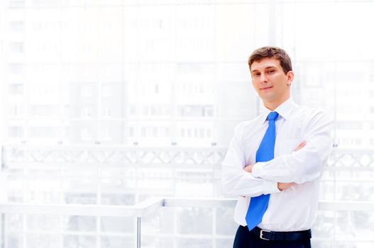 Smiling young business man crossed his arms