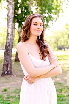 Portrait of an attractive woman in the park, crossed her arms