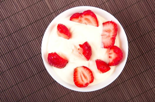 strawberries, with cream  on bamboo tablecloth, still life