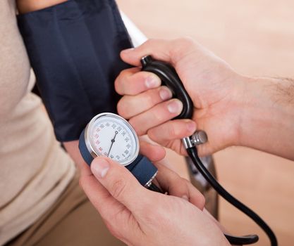 Doctor checking blood pressure of a woman. Close-up shot