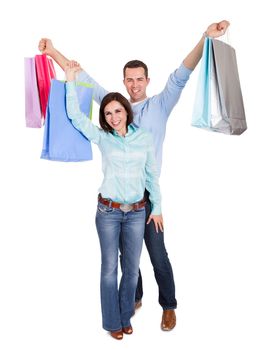 Beautiful young couple with shopping bags. Isolated on white