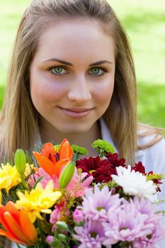 Young relaxed girl holding a wonderful bunch of flowers in the countryside