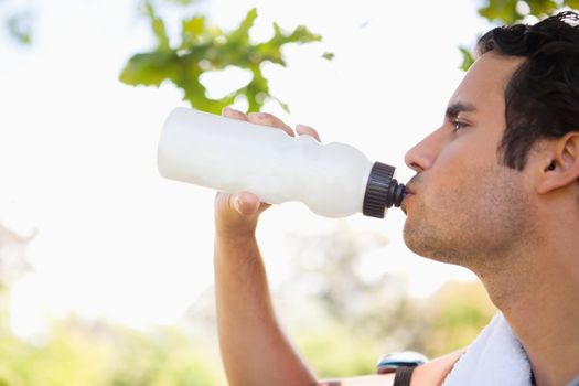 Man looking into the distance while drinking from a sports bottle