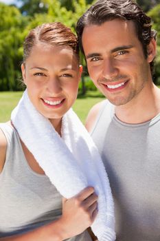 Woman holding a towel around her neck smiling with a man