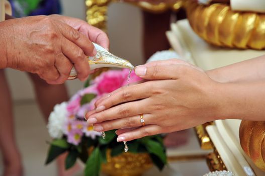 Thai wedding style ceremony with bride and groom hand