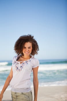 Young smiling woman standing in front of the sea