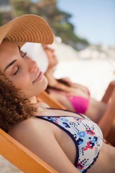 Beautiful woman napping on a deck chair while being on the beach