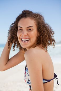 Young woman wearing a bikini while showing a great smile on the beach