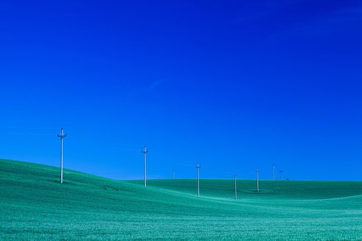 Power-transmission poles on the empty barley field at night