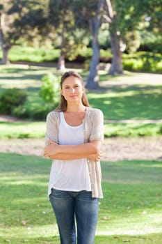 Young woman with her arms folded standing in the park