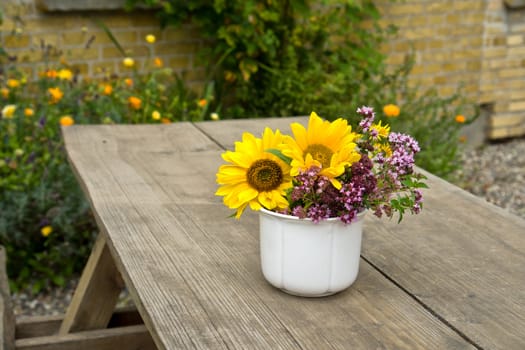 Beautiful still life image vase of vibrant flowers on a garden table