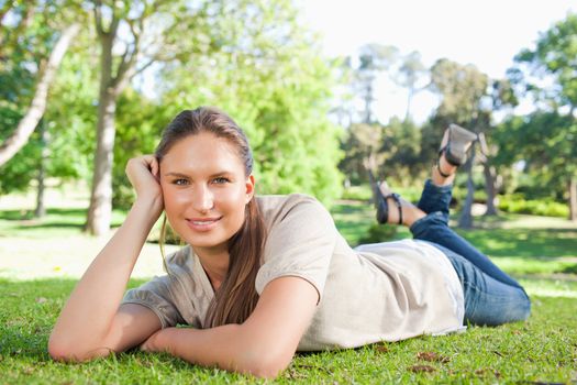 Relaxed young woman lying in the park