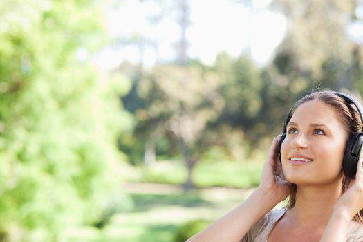 Young woman in the park listing to music