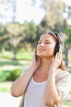 Young woman with headphones enjoying music in the park