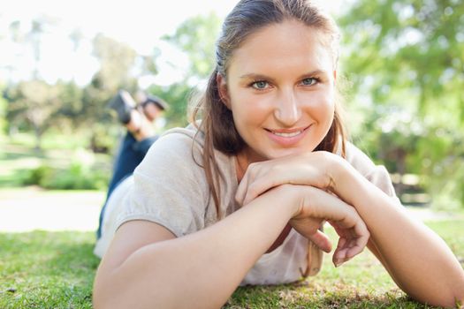 Smiling young woman lying on the grass