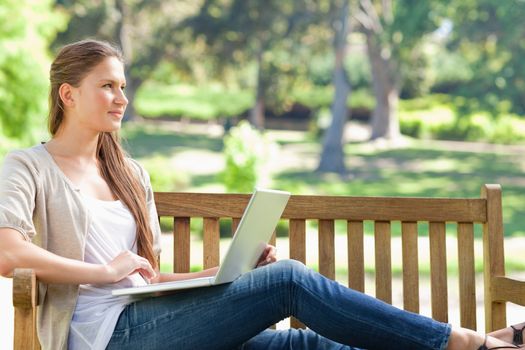 Young woman with her notebook on a park bench