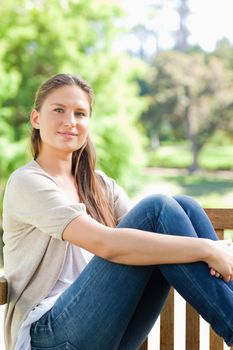 Young woman relaxing on a bench in the park