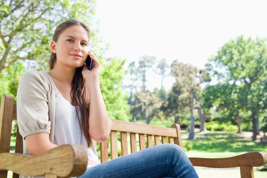 Young woman on her phone on a park bench