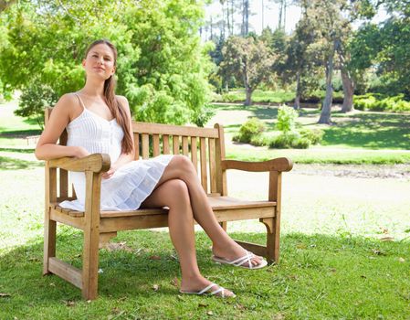 Young woman with her legs crossed sitting on a bench