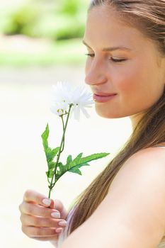 Close up of a young woman smelling a flower