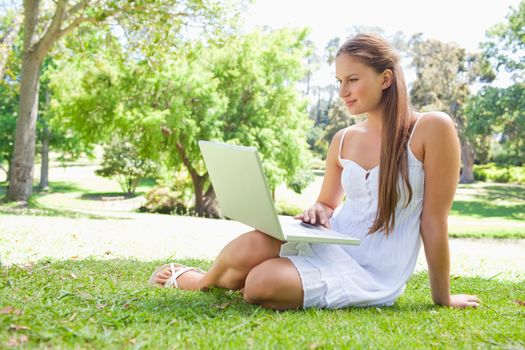 Young woman with a laptop on the lawn