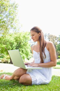 Young woman on the lawn with her laptop