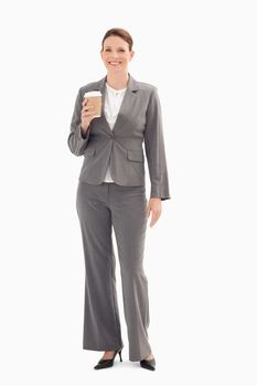 A smiling businesswoman is hold a cup of coffee