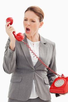 A businesswoman is shouting down the phone