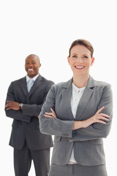 A smiling businesswoman stands in front of smiling businessman