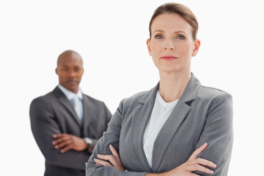 A businesswoman with folded arms stand in front of businessman with folded arms