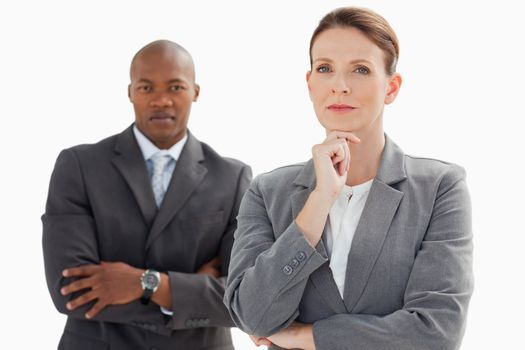 A businesswoman standing in front of businessman is resting her head on her hand 