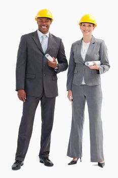 Two businesspeople are wearing hard hats