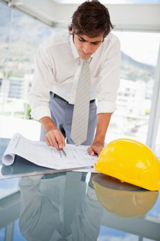 A businessman is looking at a construction drawings